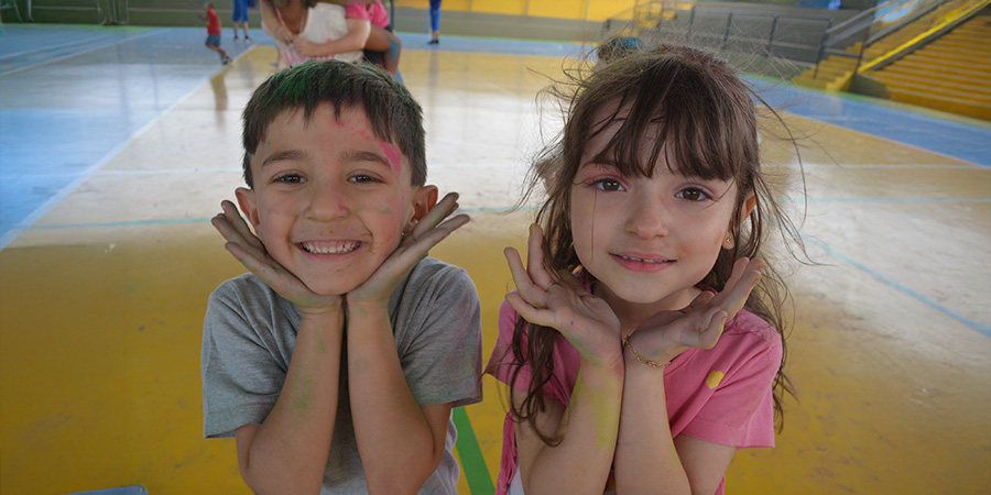 duas crianças sorrindo sujas de tinas 