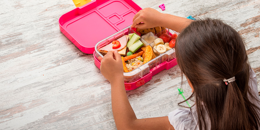 menina abrindo a lancheira saudável 