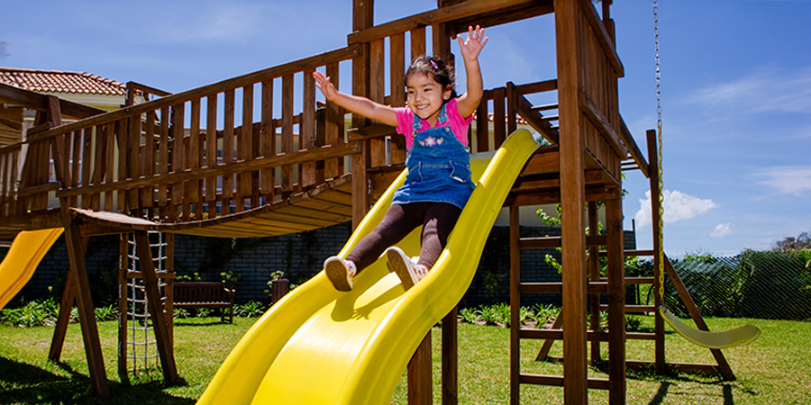 criança no escorregador - Como brincadeiras em áreas externas transformam o pensamento das crianças